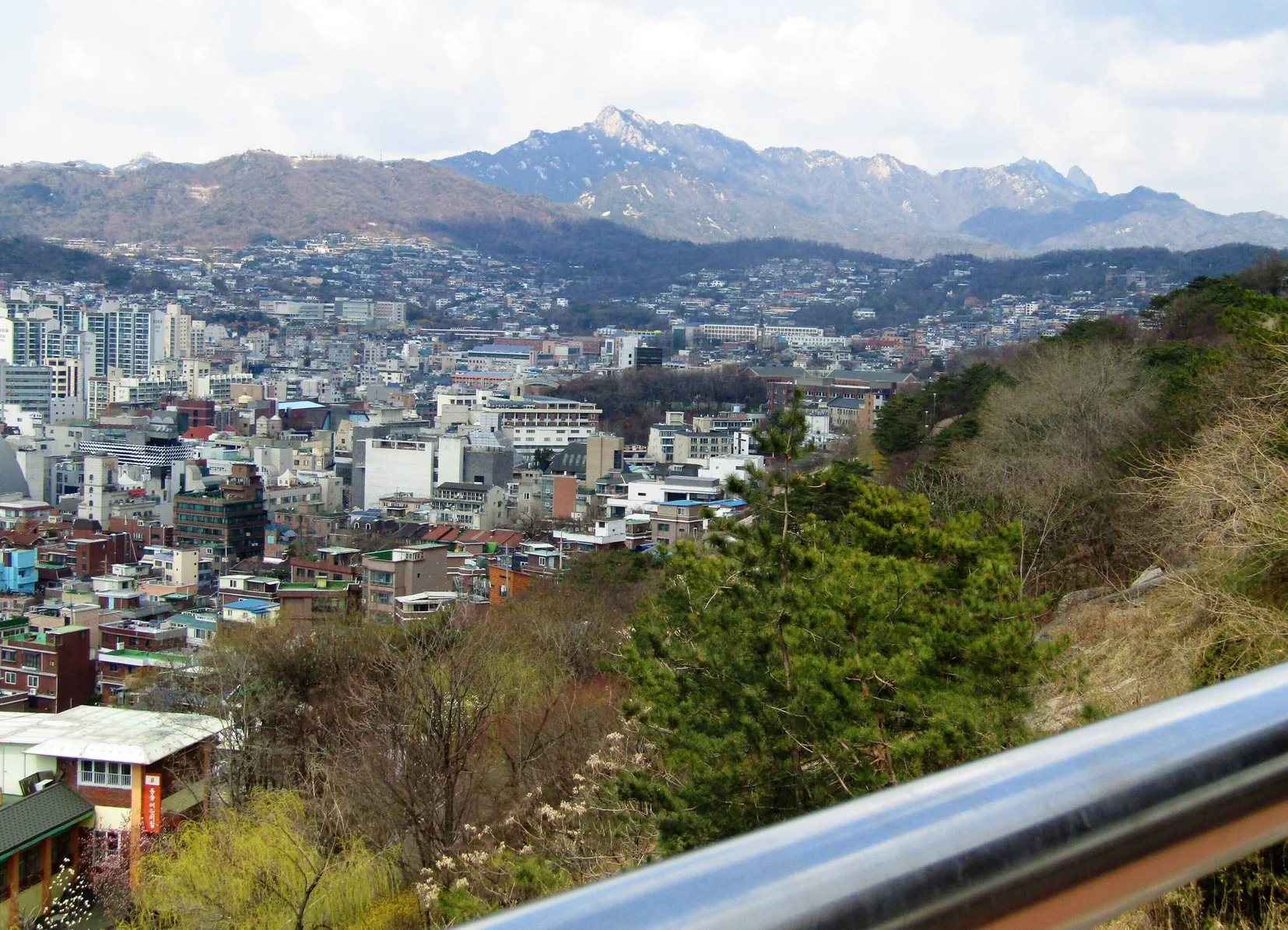 Vielas em declive do bairro de Changsin-dong, em Seul, com casas antigas e a muralha da cidade ao fundo