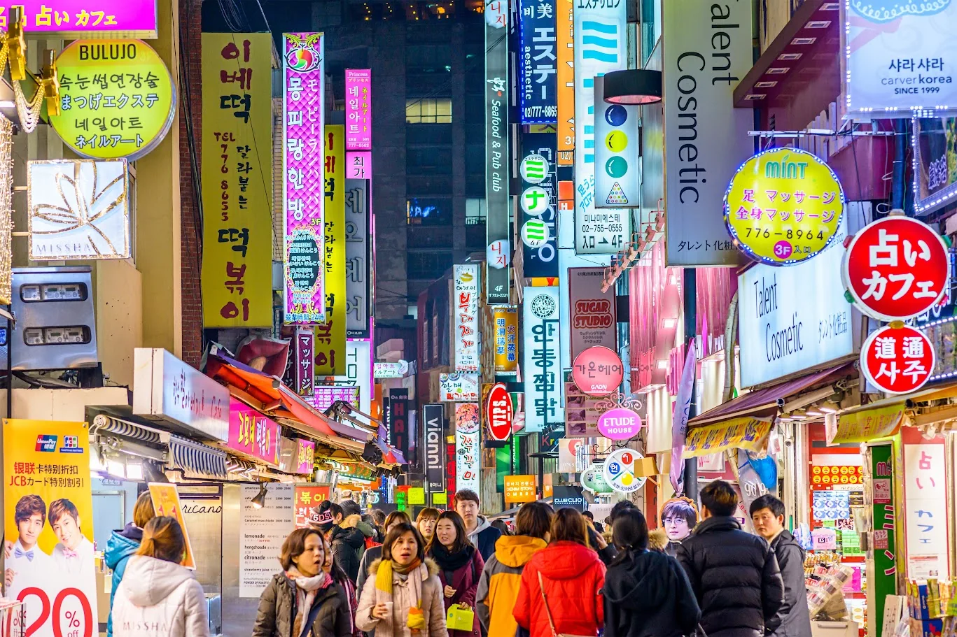 Rua de comércio lotada em Myeong-dong, Seul, com lojas e barracas de comida de rua