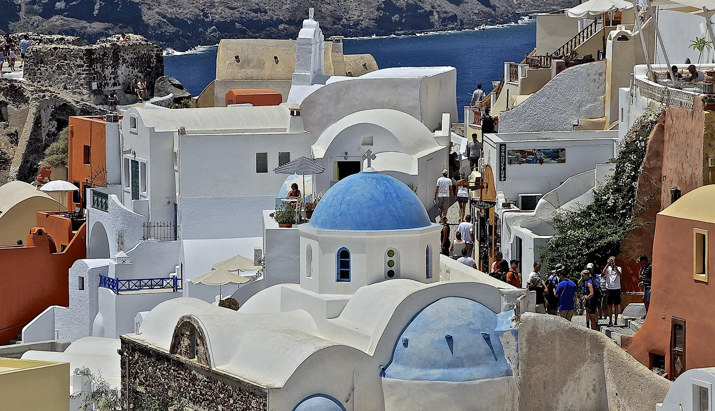 Casinhas brancas e cúpulas azuis de Oia, em Santorini, na Grécia, sobre a caldeira