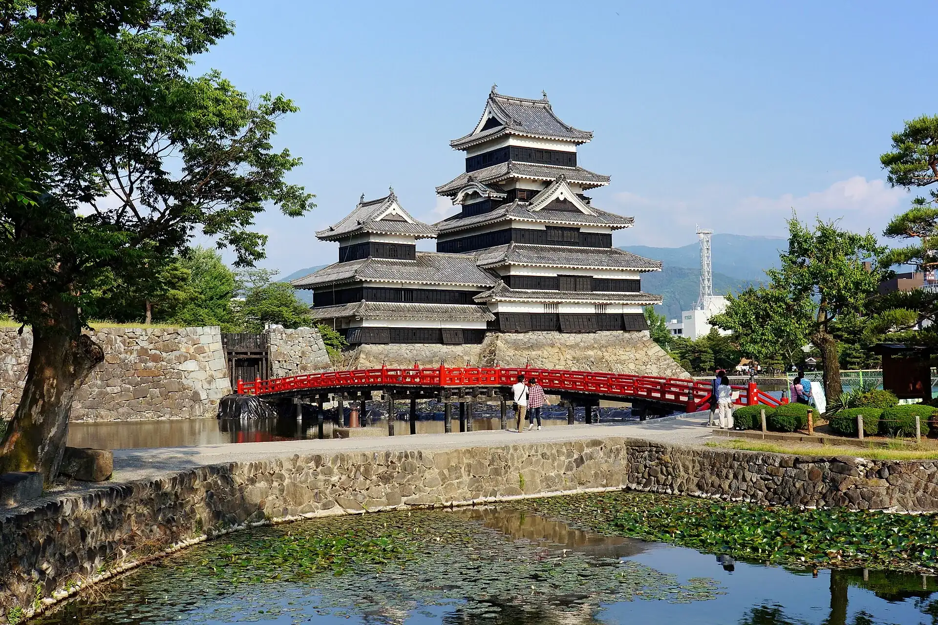 O castelo preto de Matsumoto e sua ponte vermelha, no Japão