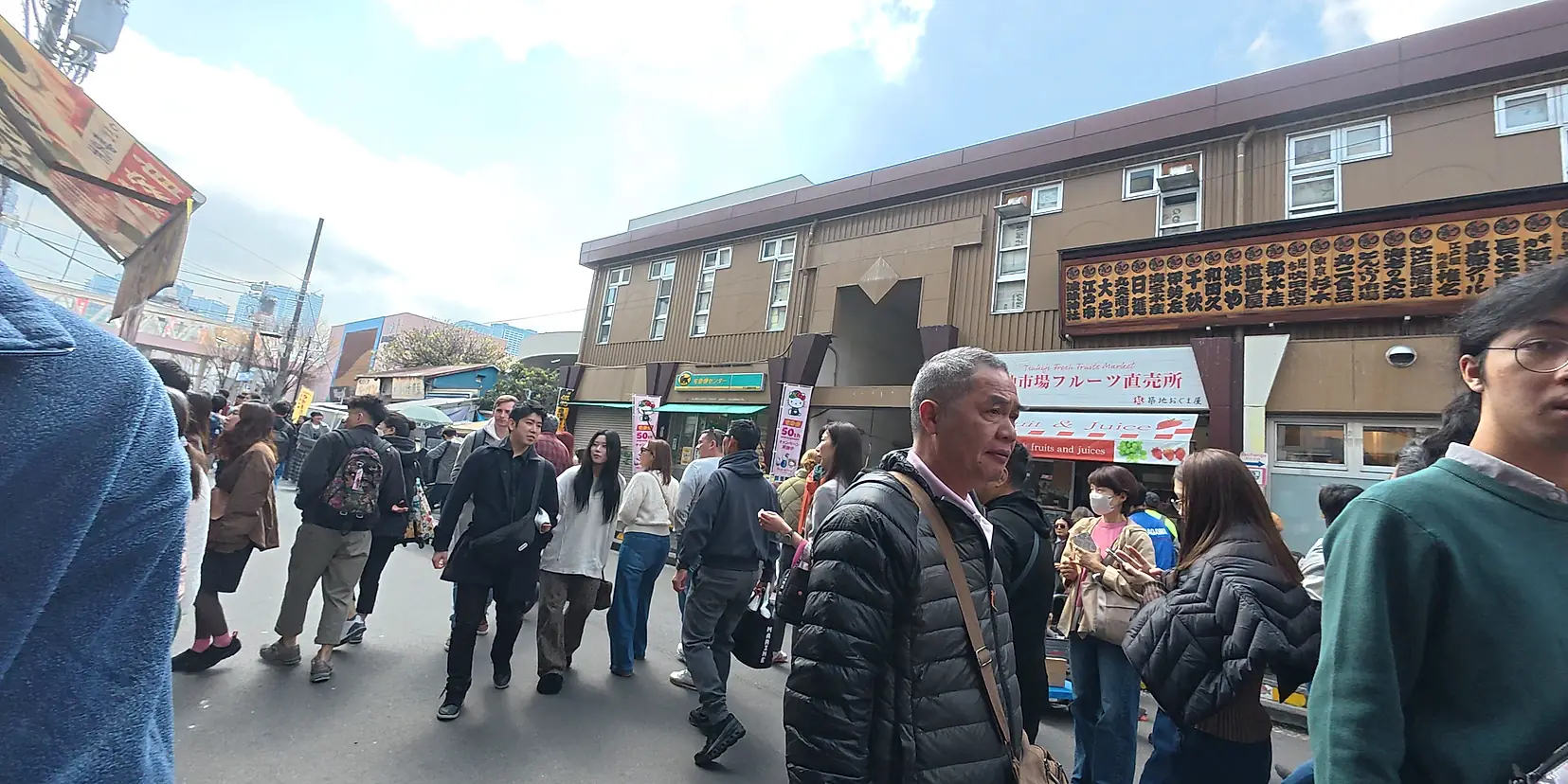Ruas movimentadas do mercado externo de Tsukiji, em Tóquio, cheias de gente e barraquinhas