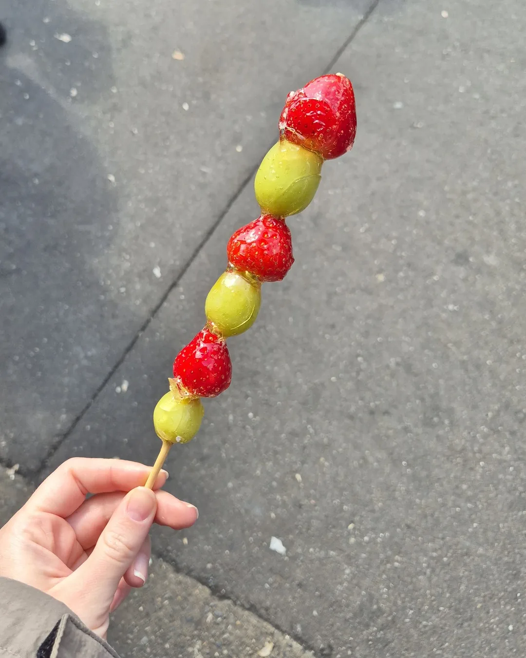 Espeto de ichigo ame com morangos e uvas cobertos de açúcar no mercado de Tsukiji