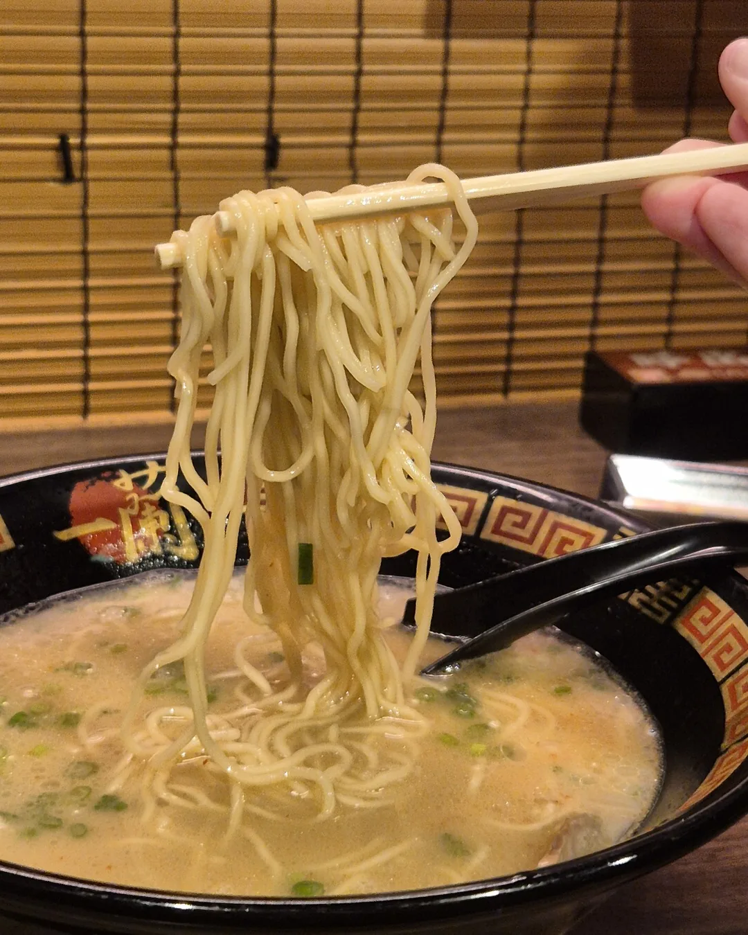 Lámen tonkotsu do Ichiran com o macarrão sendo levantado pelos hashis